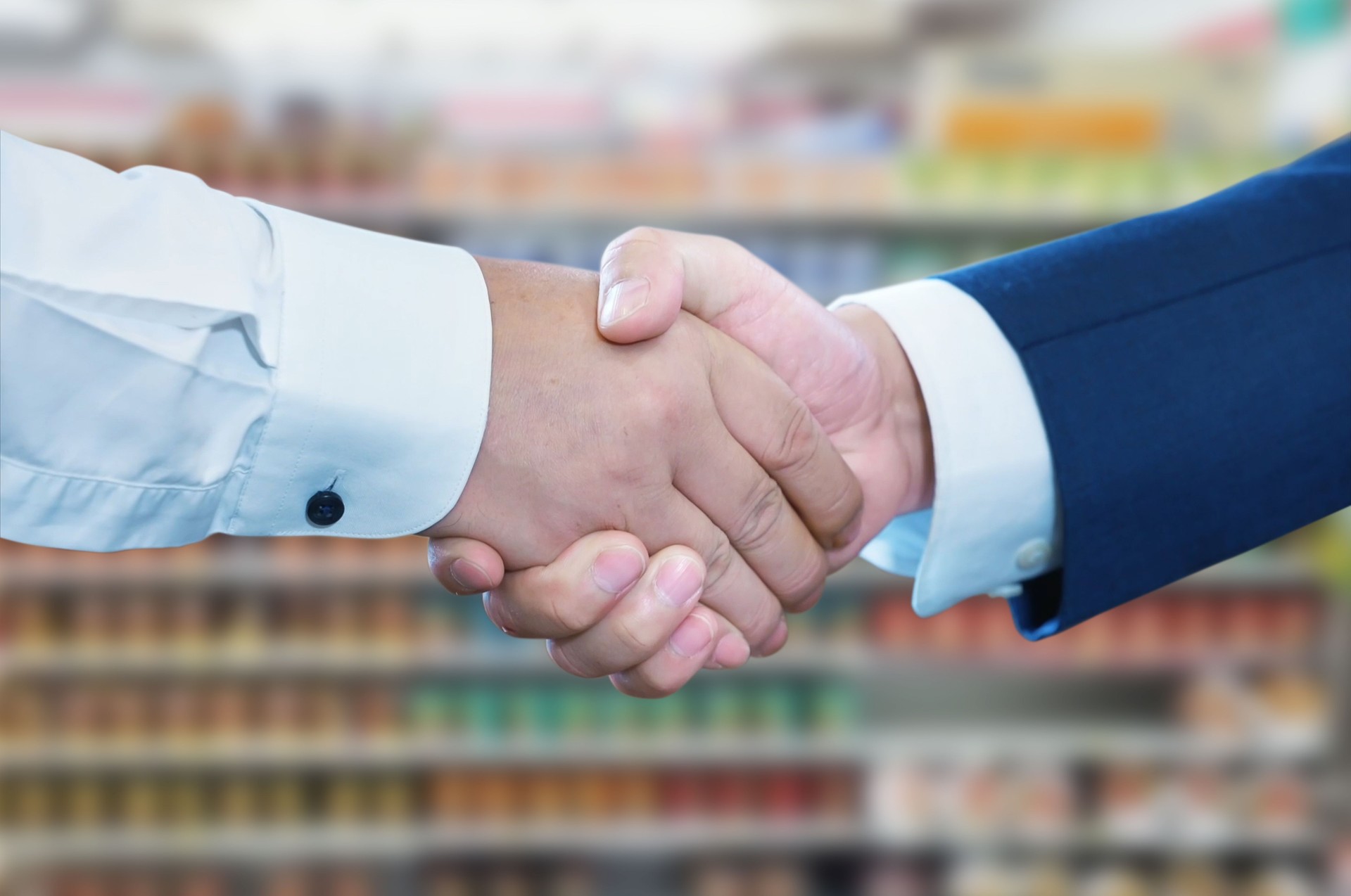 Business handshake at supermarket, Two businessman shake hand with partner to celebration partnership and business deal concept.